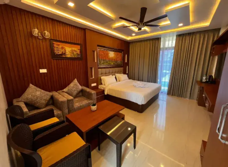 Deluxe Pool View Room with a double bed, armchairs and warm cove lighting